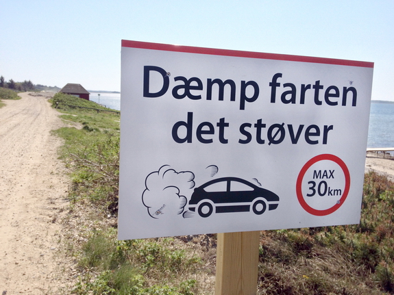 "Dæmp farten, det støver" lyder opfordringen på skilte, som "2'eren" har fået opsat ved Kystvejen. Budskabet gælder for hele sommerhusområdet. Foto: Ingrid M. Schmidt
